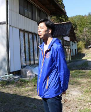 Masaaki Sakai stands outside his home in Iitate, Fukushima Prefecture.