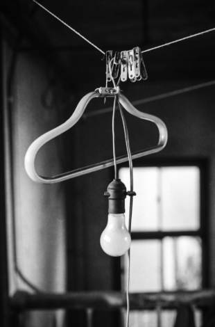 A light bulb hangs on a washing line in a hastily abandoned apartment.