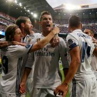 Cristiano Ronaldo (center) celebrates with his Real Madrid teammates after scoring against Atletico Madrid in the first leg of their Champions League semifinal at the Santiago Bernabeu Stadium on Tuesday. Ronaldo hat trick puts Real Madrid on brink of Champions League final