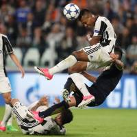 Juventus’ Alex Sandro heads the ball during the Italian side’s 2-1 victory over Monaco on Tuesday in Turin, Italy. Juventus beats Monaco to reach Champions League final
