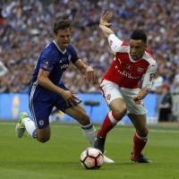 Chelsea’s Cesar Azpilicueta (left) and Arsenal’s Francis Coquelin compete for the ball during the F.A. Cup final at Wembley Stadium in London on Saturday. Cup glory gives Wenger respite