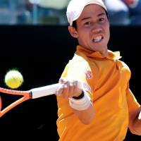 Kei Nishikori plays a shot from David Ferrer in their second-round match at the Italian Open on Wednesday. Nishikori won 7-5, 6-2. Nishikori advances to quarters in Rome