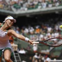 Angelique Kerber attempts to hit a shot during her match against Ekaterina Makarova during the first round of the French Open on Sunday in Paris. Daniel wins in first round; Kerber upset