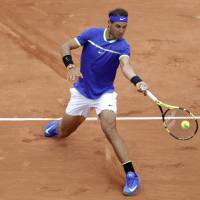 Rafael Nadal plays a shot from France’s Benoit Paire in their first-round match at the French Open on Monday. Nadal won 6-1, 6-4, 6-1. Djokovic, Nadal cruise into second round