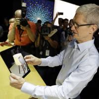 Apple CEO Tim Cook shows an iPad Pro during a showcase for new products at the Apple Worldwide Developers Conference in San Jose, California, on Monday. Apple unveils HomePod speaker, its first new product in years, and adds VR elements