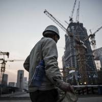 A worker walks past cranes operating on a construction site in Beijing. A Bloomberg analysis of International Monetary Fund data shows China’s transformation from rags to riches isn’t over quite yet. China's per capita GDP set for ongoing rise as the economy shifts from manufacturing to services
