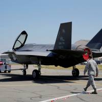 U.S. soldiers walk next to a Lockheed Martin F-35 Lightning II aircraft, as it is moved, on the eve of the 52nd Paris Air Show at Le Bourget Airport near Paris Sunday. Lockheed nears $37 billion-plus multiyear deal to sell F-35 jet to 11 nations: sources
