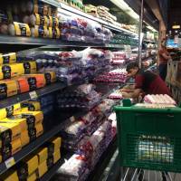 An employee fills shelves at the al-Meera market in the Qatari capital of Doha on Saturday. Japanese firms watching warily as Qatar crisis unfolds