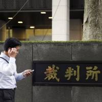 A man walks past the Tokyo District Court, where Japanese air bag maker Takata Corp filed for bankruptcy protection Monday. After global air bag recall, Takata files for bankruptcy in Japan and U.S.