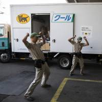 Yamato Transport Co. drivers stretch in front of a delivery truck before setting off from a branch in Musashimurayama, western Tokyo. Parcel giant Yamato's first price hike in 27 years shows fruits, limitations of Abenomics