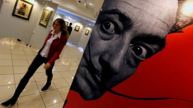A visitor walks past a portrait of artist Salvador Dali during the exhibition in St. Petersburg, Russia, in October 2014. Artist Salvador Dali's bones to be exhumed in Spain for paternity test