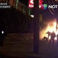 This image from video shot on Sunday shows a bystander being kicked by police officers,as he lies on the ground near flames, following an automobile chase that ended in a fiery crash in Jersey City, New Jersey. New Jersey authorities are investigating the video and a police spokesman said investigators have determined the person in the video, who also suffered burns, is not the person who was being pursued by police. Jersey City mayor to pursue charges after video surfaces of police apparently kicking burning man