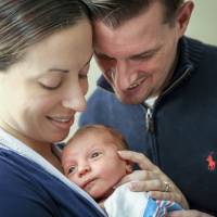In this December 2016 photo provided by Dana J. Palmer, Sarah Murray and her husband, Tom, hold their newborn son, Owen, at Bridgeport Hospital in Bridgeport, Connecticutt. Sarah Murray is participating in research on whether it’s safe for breast cancer survivors who want to get pregnant to temporarily suspend taking hormone-blocking drugs usually recommended for five years after initial treatment. She was only 29 and planning her wedding when her breast cancer was found in 2013. Pregnancy seems safe for breast cancer survivors, study finds