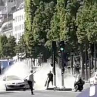 French police officers engage with a suspect outside a car on the Champs-Elysees avenue in Paris Monday in this still image obtained from social media. Champs-Elysees attacker was Islamic State loyalist on French watch list who had gun license