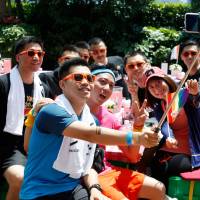 A group poses for photos after taking part in the Pride Run in Shanghai on Saturday. The run was part of Shanghai’s ninth annual gay-pride festival. Chinese gays hear wedding bells as Taiwan move fuels hope
