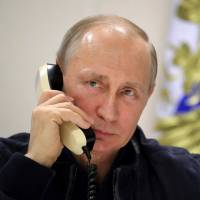 Russian President Vladimir Putin speaks on the phone aboard the Pioneering Spirit pipeline-laying ship in the Black Sea near Anapa, Russia, on Friday. CIA knew in August that Putin sought to boost Trump: report