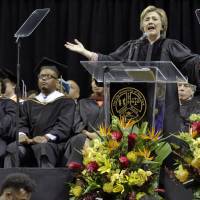 Hillary Clinton delivers the commencement address to Medgar Evers College graduates at Barclay’s Center, in Brooklyn, New York, Thursday. Seated at left are Reena Evers-Everette, and Daniel Evers-Everette, the daughter and grandson of Medgar Evers. Clinton tells Medgar Evers College grads 'never let anyone silence your voice'