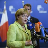 German Chancellor Angela Merkel speaks to the media as she leaves a European Council meeting at the European Union headquarters in Brussels Thursday. EU leaders agreed to roll over economic sanctions against Russia for another six months because Moscow has failed to meet its Ukraine cease-fire commitments. EU keeps sanctions on Russia due to its failure on Ukraine cease-fire