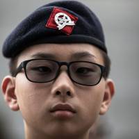 A cadet from the Hong Kong Adventure Corps takes part in a drill at their training ground in Hong Kong on May 27. Hong Kong's military-style youth groups surge in popularity ahead of handover anniversary