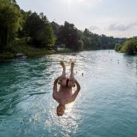 A young Swiss jumps into the Aare River on Wednesday in Bern. Heat wave scorches Europe from London to Siberia