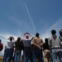 People watch a ground-based interceptor missle take off at Vandenberg Air Force base, California, on Tuesday. The U.S. military said it had intercepted a mock-up of an intercontinental ballistic missile in a first-of-its-kind test that comes amid concerns over North Korea’s weapons program. U.S. plans 'real world' test-firing of two interceptors against ICBM in 2018 as North Korea threat grows