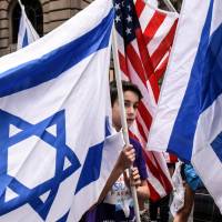 A boy is surrounded by Israeli and American flags during the “Celebrate Israel” parade along Fifth Ave. in New York City on Sunday. Research questions whether Israel considered using atomic weapons in 1967