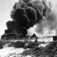 A U.S. oil tank burns after a Japanese air raid on Midway Atoll on Sept. 8 1942. U.S. professor tells story of the Battle of Midway with hand-crafted models of ships and planes