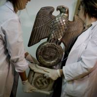 Members of the federal police carry a Nazi statue at the Interpol headquarters in Buenos Aires on Friday after police discovered on June 8 the biggest collection of Nazi artifacts in the country’s history. Hidden trove of suspected Nazi artifacts found in Argentina