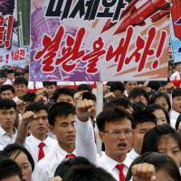 Tens of thousands of men and women pump their fists in the air and chant as they carry placards with anti-American propaganda slogans in Pyongyang’s central Kim Il Sung Square on Sunday to mark the start of the Korean War. North Korea likens Trump to Hitler, 'America First' to Nazism