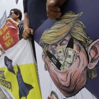 South Korean protesters hold a poster with an illustration of U.S. President Donald Trump during a rally against the deployment of an advanced U.S. missile defense system, near the U.S. Embassy in Seoul on Wednesday. Trump says China efforts on North Korea haven't 'worked out'