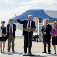 President Donald Trump, accompanied by Michael and Tammy Kushman, left, and Robert and Sarah Stoll, right, speaks in front of Air Force One about health care on Tuesday at General Mitchell International Airport in Milwaukee, Wisconsin. Mueller started investigating Trump for possible obstruction of justice just after Comey firing: Washington Post