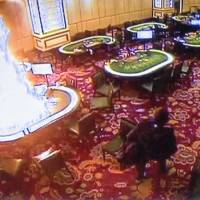Gunman Jessie Carlos walks away after setting fire to a gambling table in the Resorts World Manila entertainment and gambling complex in suburban Pasay city, southeast of Manila, on Friday in this image made from security video. Philippine police say casino attacker was indebted gambler