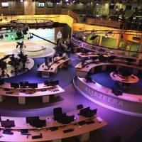 Staff members of Al-Jazeera International work at the news studio in Doha, Qatar, on Jan. 1, 2015. Kuwait has given Qatar a list of demands from Saudi Arabia and other Arab nations that includes shutting down Al-Jazeera and cutting diplomatic ties to Iran. Qatar's neighbors issue steep list of demands to end crisis