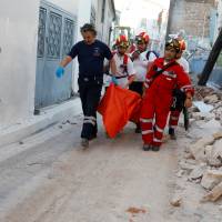 Rescue team members carry an elderly woman at the village of Vrissa on the Greek island of Lesbos after a strong earthquake shook the eastern Aegean Monday. M6.2 shallow Aegean temblor rattles Greece, Turkey, kills woman on Lesbos