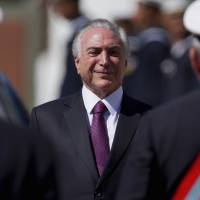 Brazil President Michel Temer smiles as he receives military honors during a ceremony in Brasilia on Friday. Brazil's Temer gets big victory in electoral court ruling