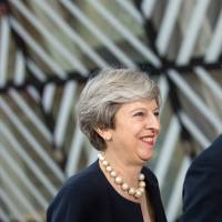 Prime Minister Theresa May and Britain’s permanent representative to the European Union, Tim Barrow, arrive for an EU summit at the Europa building in Brussels on Thursday. Britain's May wins guarded praise with offer for EU citizens at Brussels summit