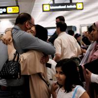 A family embraces each other as members arrive at Washington Dulles International Airport after the U.S. Supreme Court granted parts of the Trump administration’s emergency request to put its travel ban into effect later in the week pending further judicial review, in Dulles, Virginia, Monday. Conservative justices give Trump victory by partially reviving travel ban