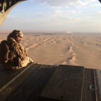 An Emirati gunner watches for enemy fire from the rear gate of a United Arab Emirates Chinook military helicopter flying over Yemen in 2015. The United Arab Emirates flatly denied allegations revealed in an Associated Press investigation last week that its forces were running secret prisons inside Yemen and torturing detainees, calling the report “completely untrue.” UAE military buildup draws scrutiny after allegations of secret torture prisons in Yemen