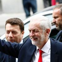 Britain’s opposition Labour party Leader Jeremy Corbyn waves as he arrives at Labour Party headquarters in central London on Friday after results came in a snap general election showed a hung parliament. May dealt crushing blow, blurring Brexit talks