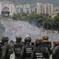 Bolivarian National Guards on an elevated highway watch as an anti-government march heads to the National Assembly in Caracas on May 3. All eyes on Venezuelan military as country grapples political crisis