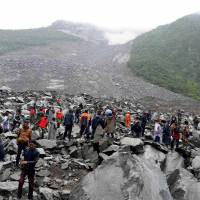 Chinese military police and rescue workers search for survivors at the site of a landslide in the Sichuan village of Xinmo on Saturday. Hopes fade in China for 118 still missing day after landslide