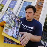 Grant Berardo, a junior at Wall High School, flips through the 2017 Wall High School yearbook in Wall, New Jersey, on June 9. The yearbook includes a photo of him wearing a digitally altered T-shirt that originally included the words “Trump Make America Great Again.” Superintendent Cheryl Dyer said Berardo’s Trump T-shirt was digitally painted a nondescript black even though the shirt did not violate the school’s dress code. Trump thanks pair whose yearbook references to him had been deleted