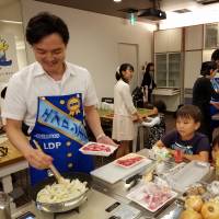 Junior lawmaker Takeshi Ninoyu, who says cooking is his hobby, sets himself apart from other LDP lawmakers by deftly fixing stew for his wife and two little children at an event in Tokyo on Wednesday. LDP lawmakers take to the kitchen to promote female workplace empowerment