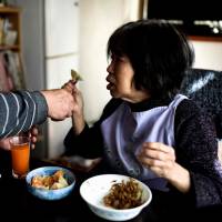 Kanemasa Ito feeds his wife Kimiko, who has dementia, at their home in Kawasaki in January. Aging Japan faces dementia time bomb