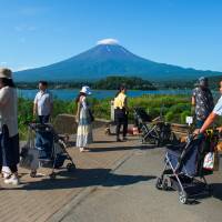 Tourists visit Lake Kawaguchi near Mount Fuji. HomeAway, Expedia Inc.’s home-rental subsidiary, expects the June enactment of a new law to help boost its business in Japan. New home-sharing law may give HomeAway the edge over rival Airbnb