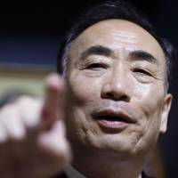 Yasunori Kagoike, former head of the school operator Moritomo Gakuen, points a finger to the media at his home in Osaka Prefecture Tuesday after prosecutors searched his home over the alleged fraudulent receipt of subsidies. Moritomo Gakuen suspected of padding student numbers to claim special subsidies