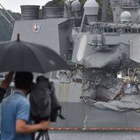 A TV crew films the damage to the guided missile destroyer USS Fitzgerald at its mother port in Yokosuka, Kanagawa Prefecture, Sunday. A number of missing American sailors have been found dead in flooded areas of a destroyer that collided with a container ship off Japan’s coast, the U.S. Navy said on Sunday. Sailor tried to save shipmates after collision off Japan until cabin flooded: mother