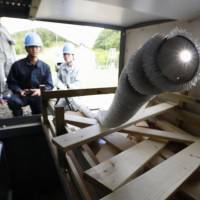 Researchers demonstrate Monday how a snake-like robot can go under and over obstacles at Tohoku University in Sendai. Japanese team develops snake-like robot to help in disasters