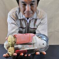 Tsutomu Takeuchi, senior manager at Toshiba’s Fukushima Restoration and Fuel Cycle Project Engineering Department, shows off a robot it claims can probe water-filled reactor 3 at the defunct Fukushima No. 1 nuclear plant. Toshiba unveils submersible video robot to probe reactor 3 at Fukushima No. 1 plant