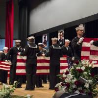 Sailors fold U.S. flags during a memorial ceremony at Fleet Activities in Yokosuka, Kanagawa Prefecture, on Tuesday for seven sailors assigned to the USS Fitzgerald who were killed in a June 17 collision. U.S. Navy holds Japan memorial for sailors killed in crash